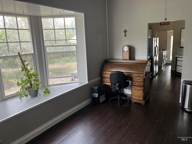 office area featuring washing machine and dryer, dark wood-style flooring, and baseboards