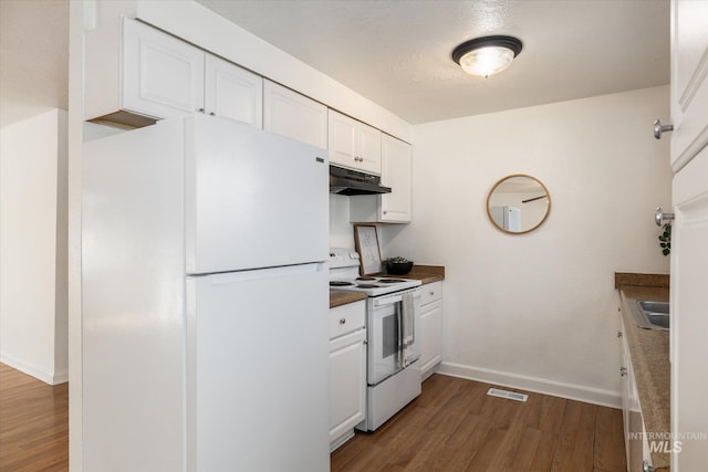 kitchen with visible vents, under cabinet range hood, white cabinets, white appliances, and dark wood-style flooring