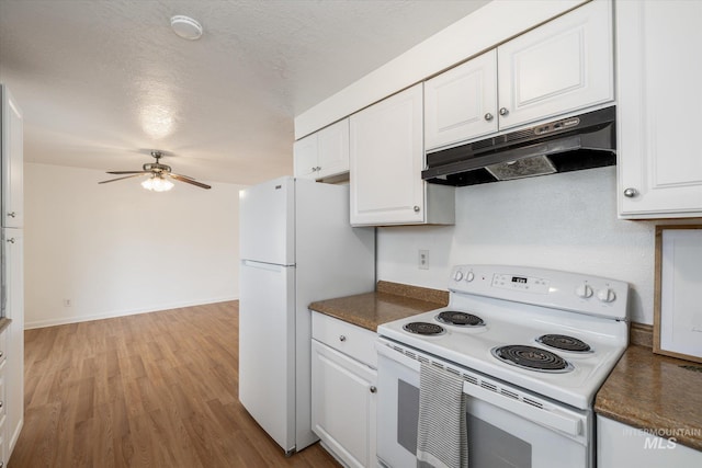 kitchen featuring light wood-type flooring, under cabinet range hood, dark countertops, white cabinetry, and white appliances