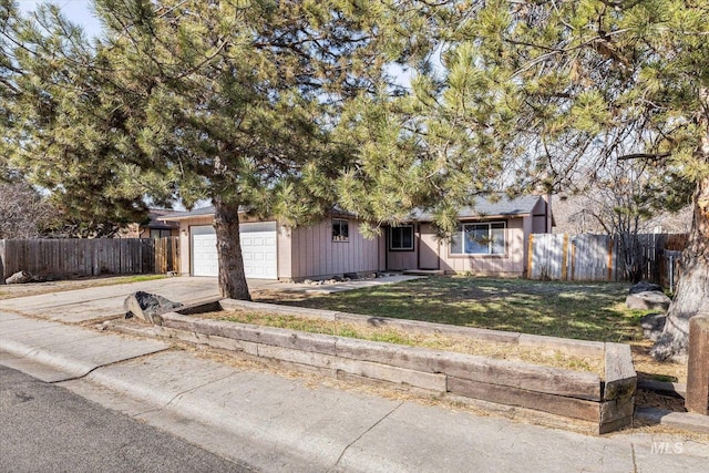 view of front facade featuring driveway, a front yard, a garage, and fence