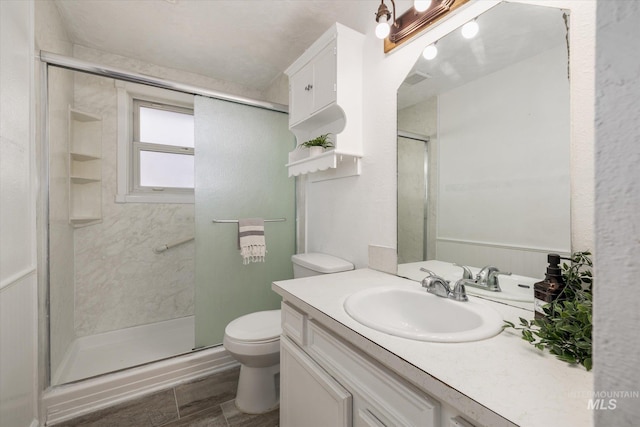 full bath featuring wood finished floors, toilet, a stall shower, and vanity