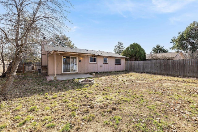 rear view of property with a patio area, a chimney, and a fenced backyard