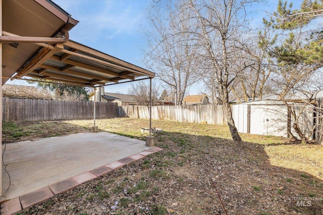 view of yard featuring a fenced backyard, an outdoor structure, and a patio