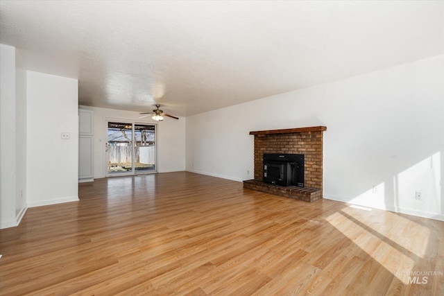 unfurnished living room featuring a ceiling fan, baseboards, and light wood finished floors