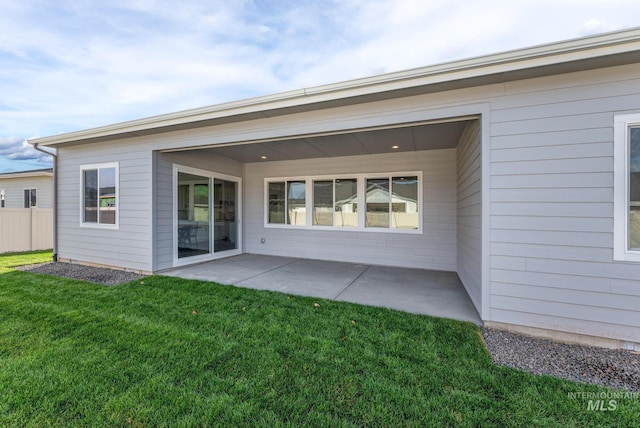 back of property featuring a patio, fence, and a lawn