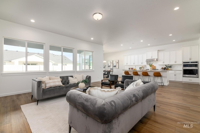 living room featuring recessed lighting, a wealth of natural light, and wood finished floors