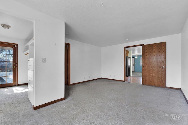 carpeted empty room with a textured ceiling