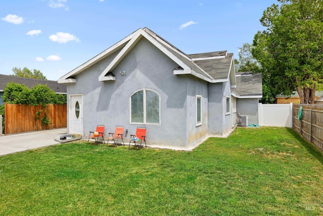 rear view of house featuring central AC, a lawn, and a patio