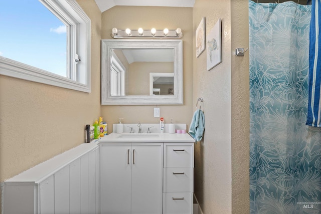726 Wyoming St, Gooding, ID 83330 - full bathroom with lofted ceiling, a textured wall, a shower with shower curtain, and vanity