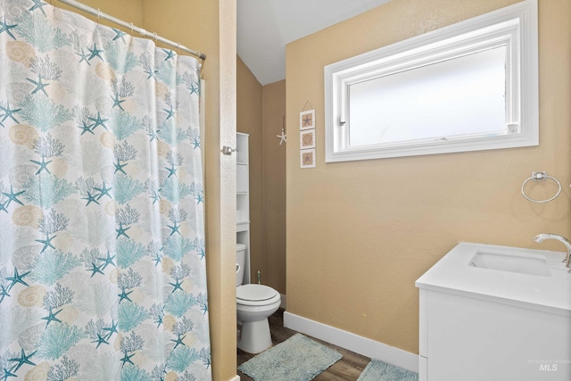 726 Wyoming St, Gooding, ID 83330 - bathroom with toilet, vanity, wood finished floors, a shower with curtain, and baseboards