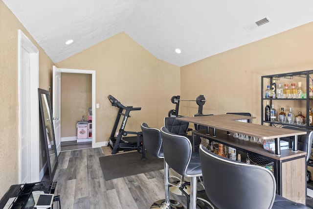 726 Wyoming St, Gooding, ID 83330 - office with baseboards, visible vents, wood finished floors, vaulted ceiling, and a bar
