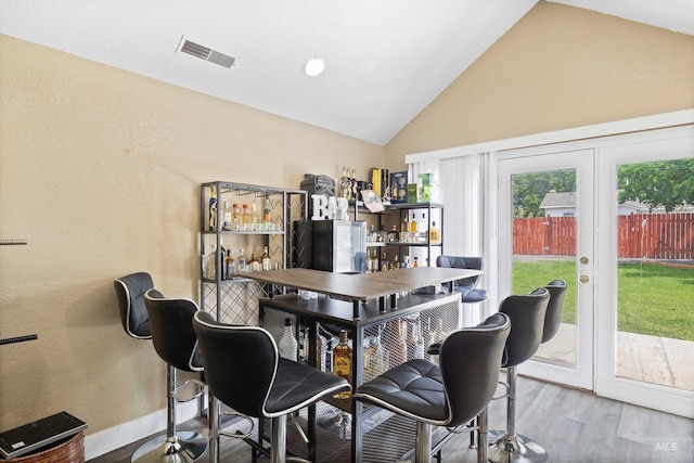 726 Wyoming St, Gooding, ID 83330 - dining room with baseboards, visible vents, lofted ceiling, wood finished floors, and french doors