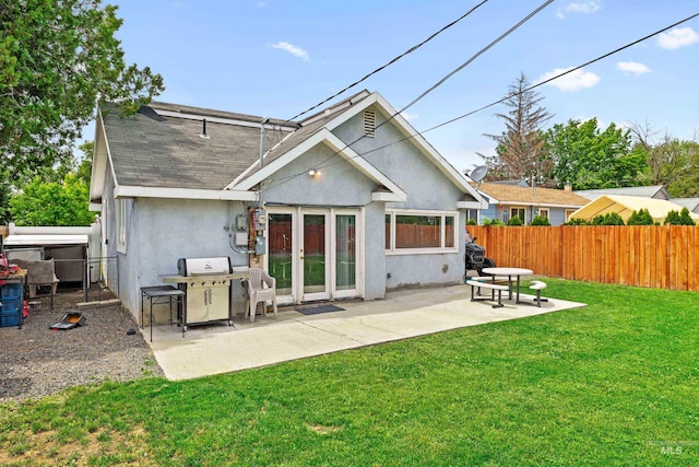 726 Wyoming St, Gooding, ID 83330 - back of property with a yard, a patio, stucco siding, a shingled roof, and a fenced backyard