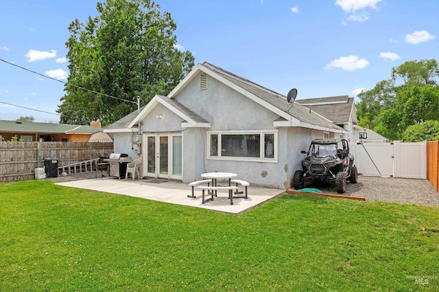 726 Wyoming St, Gooding, ID 83330 - rear view of property featuring a lawn, a patio, a fenced backyard, a gate, and stucco siding