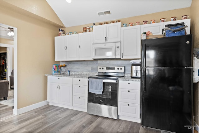 726 Wyoming St, Gooding, ID 83330 - kitchen with lofted ceiling, white microwave, white cabinets, freestanding refrigerator, and stainless steel electric stove