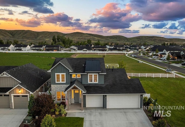 7805 W Cardinal Dr, Boise, ID 83714 - view of front of house featuring concrete driveway, stone siding, a mountain view, and a residential view