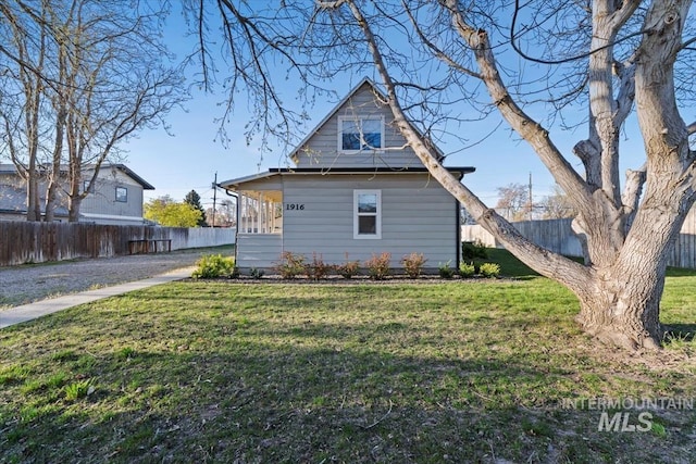 back of property with fence and a yard