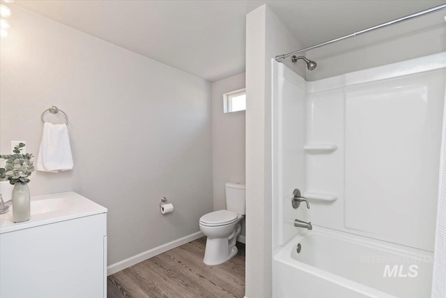 full bath featuring wood finished floors, vanity, baseboards, toilet, and shower / bathtub combination