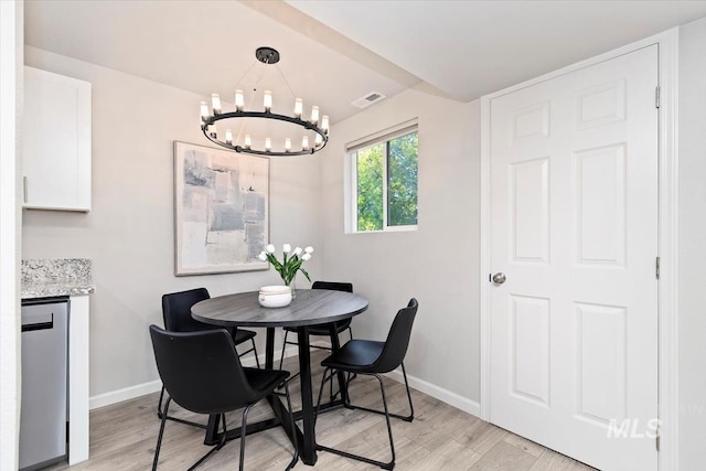 dining area with an inviting chandelier, lofted ceiling, light wood finished floors, and baseboards