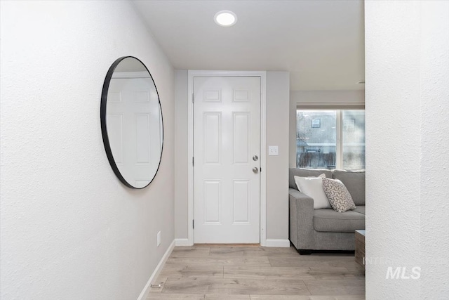 foyer entrance with light wood-style flooring, baseboards, and recessed lighting