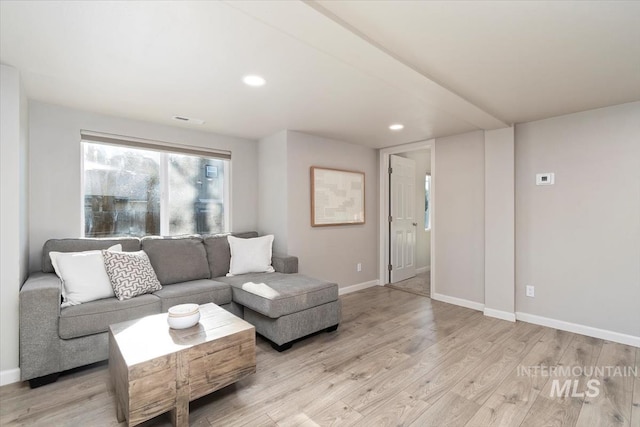living room with light wood-style flooring, baseboards, and recessed lighting