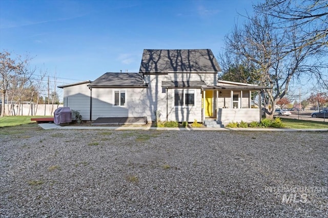 view of front of property with roof with shingles and fence