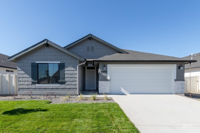 ranch-style home with a garage, fence, driveway, roof with shingles, and a front yard