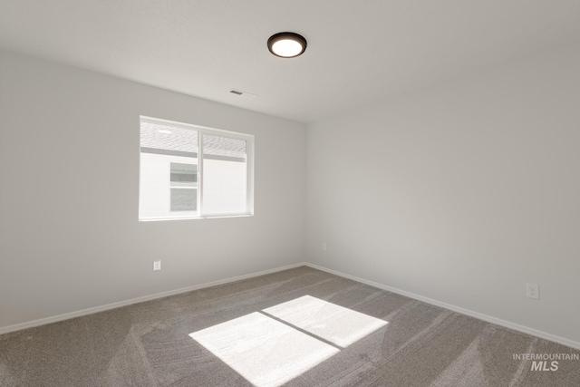 carpeted spare room with baseboards