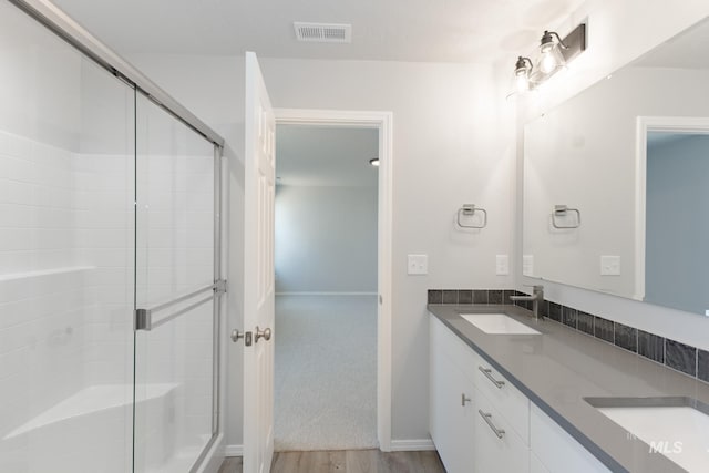 full bath featuring a sink, visible vents, and a shower stall