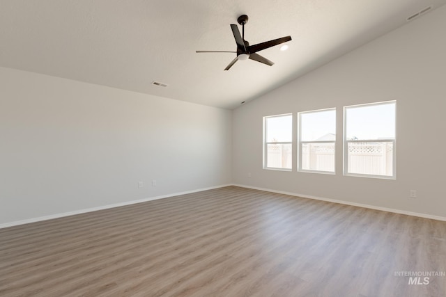 spare room featuring light wood-style floors, lofted ceiling, visible vents, and ceiling fan