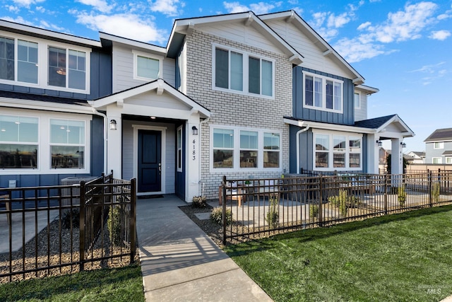 view of front of home featuring brick siding and a fenced front yard