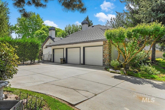 5130 N Lakemont Ln, Garden City, ID 83714 - view of home's exterior with a chimney, concrete driveway, stone siding, an attached garage, and a tile roof