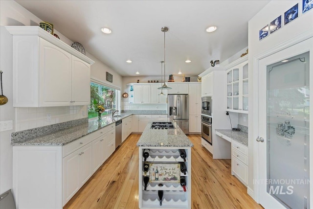 5130 N Lakemont Ln, Garden City, ID 83714 - kitchen featuring stainless steel appliances, white cabinetry, a kitchen island, light stone countertops, and light wood finished floors