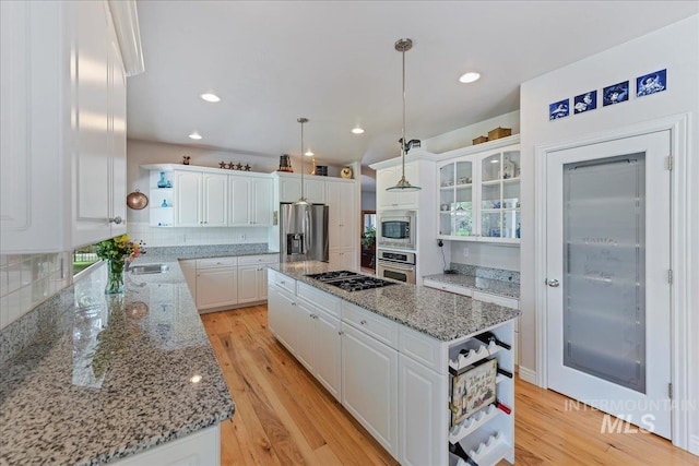 5130 N Lakemont Ln, Garden City, ID 83714 - kitchen featuring open shelves, stainless steel appliances, a center island, white cabinets, and backsplash