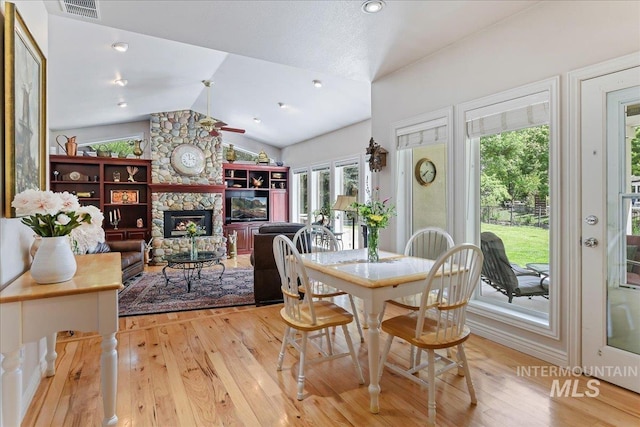 5130 N Lakemont Ln, Garden City, ID 83714 - dining room featuring light wood-style flooring, lofted ceiling, and a stone fireplace