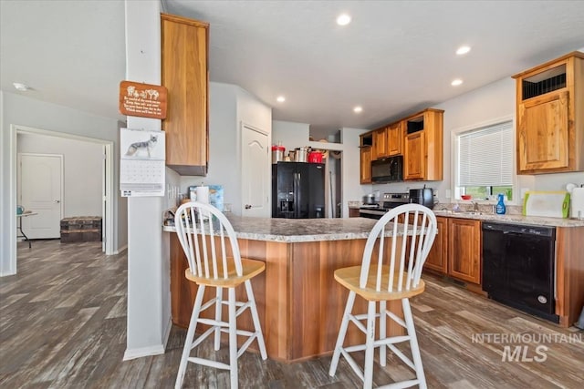 1639 Cuddy View Dr, Council, ID 83612 - kitchen with a kitchen breakfast bar, dark hardwood / wood-style flooring, kitchen peninsula, and black appliances