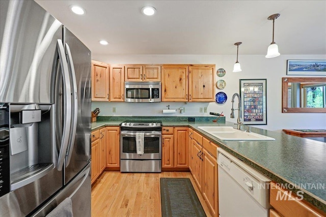1425 Clements Rd Unit 5, Mccall, ID 83638 - kitchen featuring appliances with stainless steel finishes, a sink, dark countertops, light wood-style flooring, and hanging light fixtures
