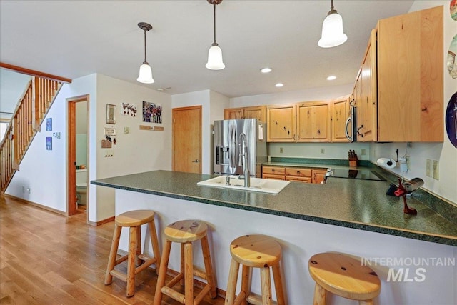 1425 Clements Rd Unit 5, Mccall, ID 83638 - kitchen featuring appliances with stainless steel finishes, a sink, dark countertops, a peninsula, and light wood-style flooring