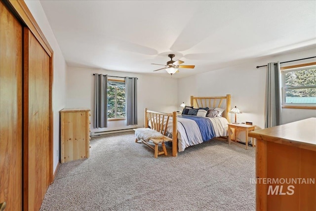 1425 Clements Rd Unit 5, Mccall, ID 83638 - bedroom with light colored carpet, multiple windows, a baseboard heating unit, and ceiling fan