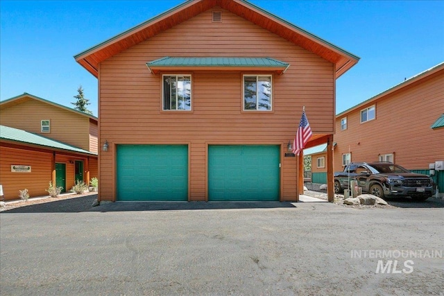 1425 Clements Rd Unit 5, Mccall, ID 83638 - view of front of house with an attached garage, metal roof, a standing seam roof, and asphalt driveway