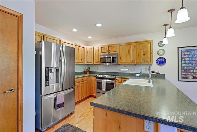 1425 Clements Rd Unit 5, Mccall, ID 83638 - kitchen featuring stainless steel appliances, a sink, dark countertops, a peninsula, and light wood-type flooring