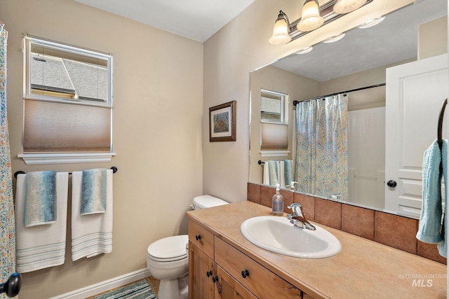 bathroom with walk in shower, vanity, and toilet