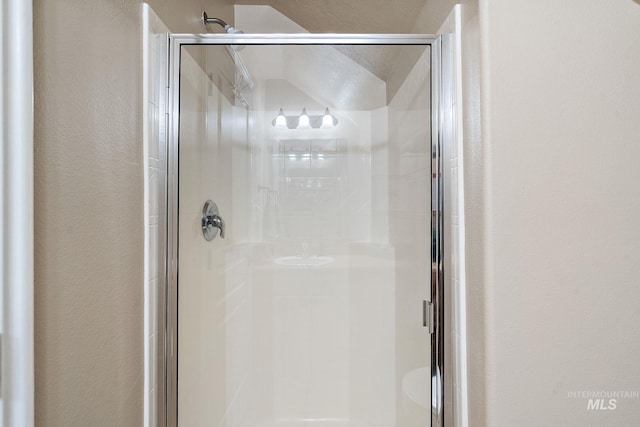 bathroom with an enclosed shower and a textured ceiling