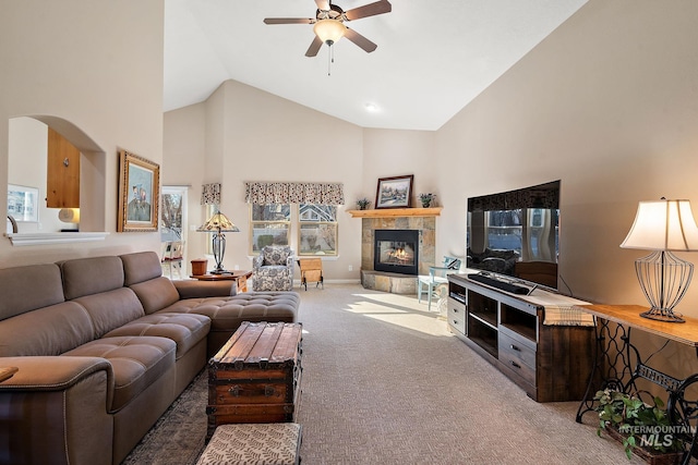 living room featuring a tiled fireplace, ceiling fan, high vaulted ceiling, and carpet