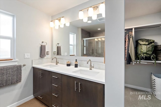 bathroom featuring vanity, backsplash, and walk in shower