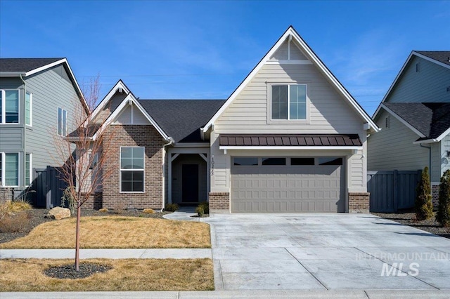 craftsman house featuring a standing seam roof, fence, brick siding, and driveway