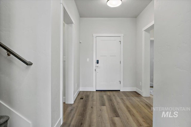 entryway featuring stairs, visible vents, wood finished floors, and baseboards