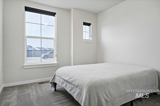 carpeted bedroom featuring visible vents and baseboards