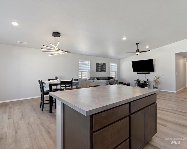 kitchen with baseboards, light countertops, visible vents, and light wood-style floors