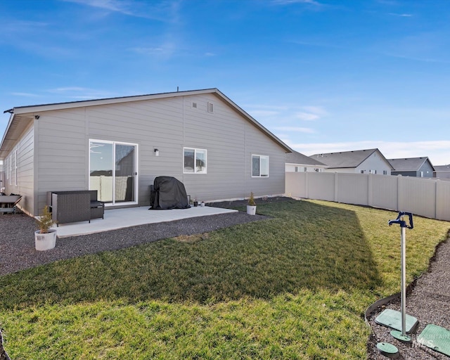 back of house featuring a yard, a patio area, and fence